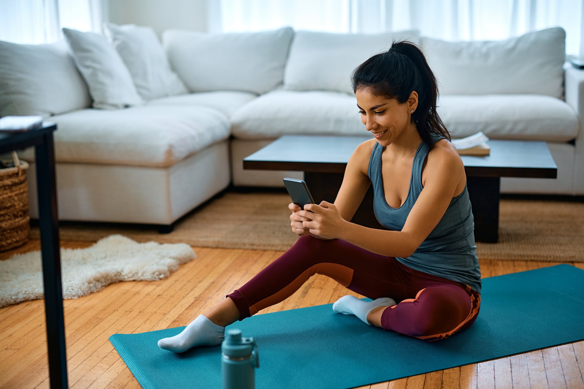 happy-athletic-woman-texting-on-cell-phone-while-e-2023-03-13-21-33-45-utc